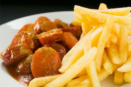 Currywurst (sausage with ketchup & curry powder) & chips on plate Stock Photo - Premium Royalty-Free, Code: 659-01862213