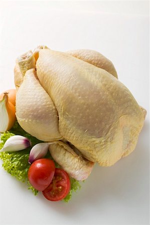 Fresh oven-ready chicken, garnished with vegetables Fotografie stock - Premium Royalty-Free, Codice: 659-01862245