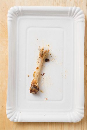 Chicken bone on paper plate Stock Photo - Premium Royalty-Free, Code: 659-01862257