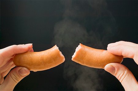 Hand holding a halved frankfurter Stock Photo - Premium Royalty-Free, Code: 659-01862279