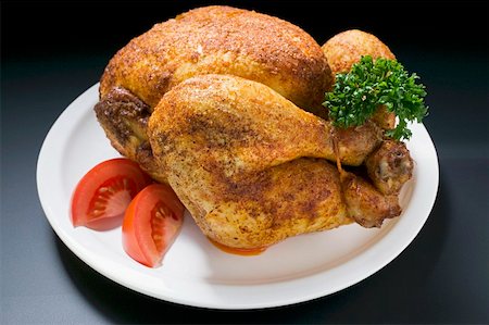 Spicy roast chicken, garnished with parsley and tomato Fotografie stock - Premium Royalty-Free, Codice: 659-01862272