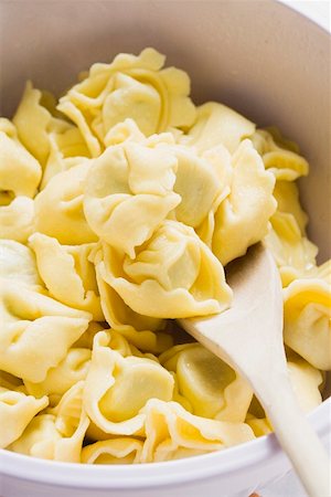 simsearch:659-01863699,k - Tortellini in white bowl with wooden spoon (detail) Stock Photo - Premium Royalty-Free, Code: 659-01862375