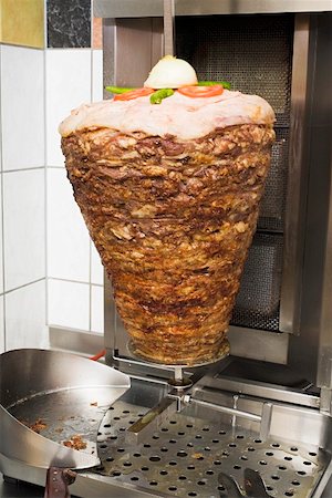 simsearch:659-01862721,k - Döner kebab meat on spit in front of grill in restaurant Foto de stock - Sin royalties Premium, Código: 659-01862484