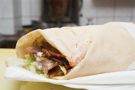 doner kebap kebab - Döner wrap on paper napkin in snack bar Stock Photo - Premium Royalty-Free, Code: 659-01862485