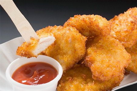 Pépites de poulet avec du ketchup dans le plat de papier Photographie de stock - Premium Libres de Droits, Code: 659-01862631