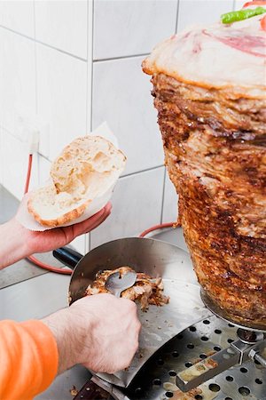 simsearch:659-01862723,k - Faire un döner kebab : remplissage du pain pita avec de la viande Photographie de stock - Premium Libres de Droits, Code: 659-01862714