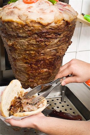 simsearch:659-01862486,k - Faire un döner kebab : remplissage du pain pita avec de la viande Photographie de stock - Premium Libres de Droits, Code: 659-01862741