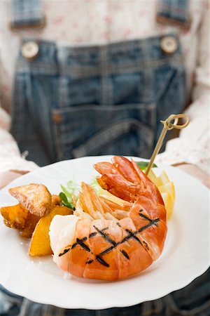 simsearch:659-01844703,k - Person holding grilled king prawn on plate Stock Photo - Premium Royalty-Free, Code: 659-01862822