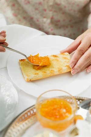 Marmelade d'oranges étalée sur du pain grillé Photographie de stock - Premium Libres de Droits, Code: 659-01862880