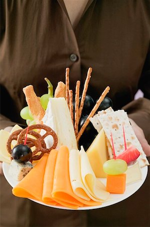 finger food people - Woman serving a cheese platter Stock Photo - Premium Royalty-Free, Code: 659-01862893