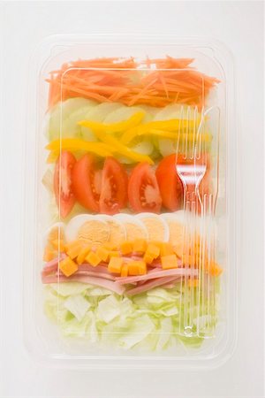 salad top view isolated - Iceberg lettuce, ham, cheese, egg & vegetables in plastic tray Stock Photo - Premium Royalty-Free, Code: 659-01862915