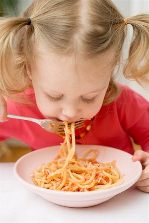 simsearch:659-03521588,k - Small girl eating noodles with tomatoes Fotografie stock - Premium Royalty-Free, Codice: 659-01863085