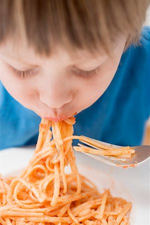 simsearch:659-01863088,k - Small boy eating noodles with tomatoes Foto de stock - Sin royalties Premium, Código: 659-01863091