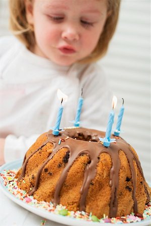 soplar velas - Small girl blowing out candles on birthday cake Foto de stock - Sin royalties Premium, Código: 659-01863101