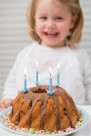 Small girl behind birthday cake with candles Stock Photo - Premium Royalty-Free, Code: 659-01863102