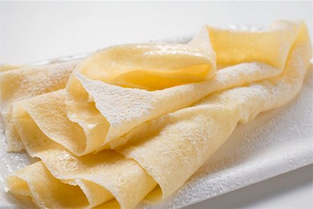 Wafer-thin crêpes with icing sugar on paper plate Stock Photo - Premium Royalty-Free, Code: 659-01863111