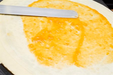 Spreading a crêpe with jam Stock Photo - Premium Royalty-Free, Code: 659-01863120