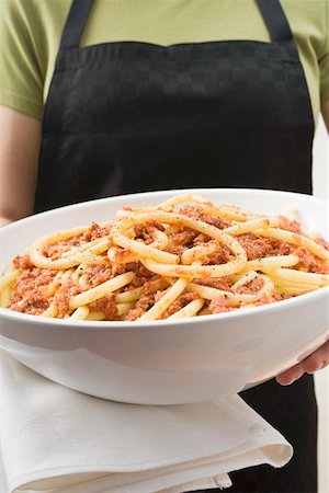 pasta bolognese - Person holding bowl of macaroni with mince sauce Stock Photo - Premium Royalty-Free, Code: 659-01863169