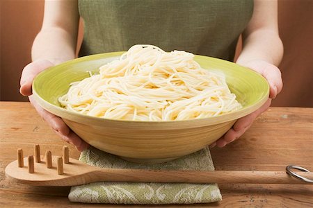 spaghetti server - Woman holding bowl of cooked spaghetti Stock Photo - Premium Royalty-Free, Code: 659-01863162