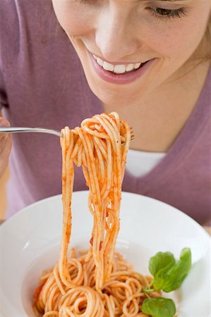 simsearch:659-01863088,k - Woman eating spaghetti with tomato sauce Foto de stock - Sin royalties Premium, Código: 659-01863208