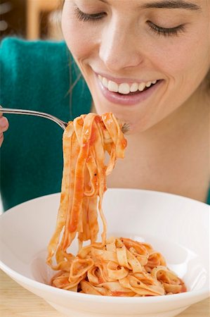 simsearch:659-01855701,k - Woman eating ribbon pasta with tomato sauce Stock Photo - Premium Royalty-Free, Code: 659-01863209