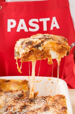 Person taking portion of lasagne out of baking dish Stock Photo - Premium Royalty-Free, Code: 659-01863215