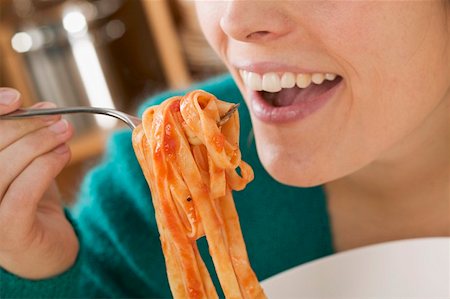 simsearch:659-01863088,k - Woman eating ribbon pasta with tomato sauce Foto de stock - Sin royalties Premium, Código: 659-01863210