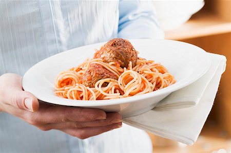 simsearch:659-01854859,k - Person holding plate of spaghetti with meatballs Foto de stock - Sin royalties Premium, Código: 659-01863257