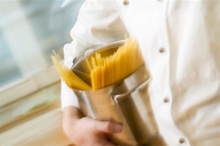 simsearch:659-01852572,k - Chef hurrying through kitchen with spaghetti in pan Stock Photo - Premium Royalty-Free, Code: 659-01863297