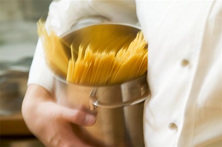 Chef hurrying through kitchen with spaghetti in pan Stock Photo - Premium Royalty-Free, Code: 659-01863298