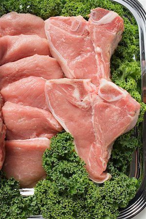 T-bone steaks and beef fillets surrounded by parsley Stock Photo - Premium Royalty-Free, Code: 659-01863375