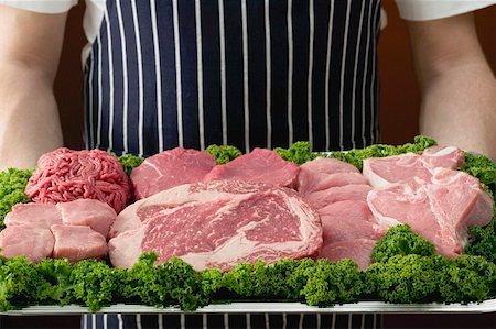 Person holding tray of various cuts of meat Fotografie stock - Premium Royalty-Free, Codice: 659-01863425