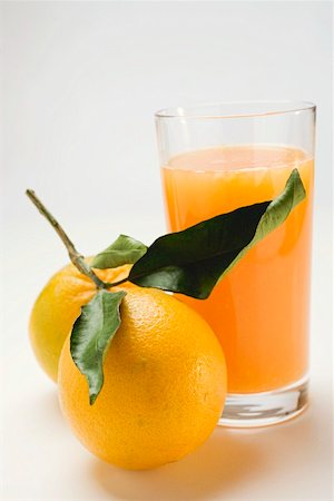 simsearch:659-08147293,k - Glass of orange juice and two oranges with leaves Stock Photo - Premium Royalty-Free, Code: 659-01863544