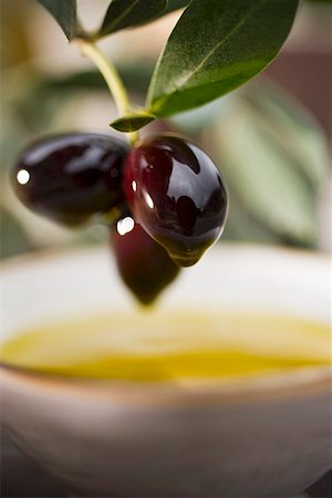 Olive sprig with black olives over bowl of olive oil Foto de stock - Sin royalties Premium, Código: 659-01863619