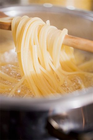 Lifting cooked ribbon pasta out of the water Stock Photo - Premium Royalty-Free, Code: 659-01863672