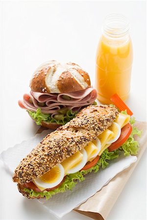 Egg in granary roll, sausage in pretzel roll, orange juice Foto de stock - Sin royalties Premium, Código: 659-01863762