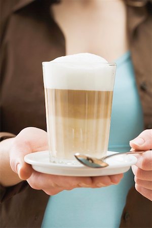 Woman holding a glass of latte macchiato Stock Photo - Premium Royalty-Free, Code: 659-01863872