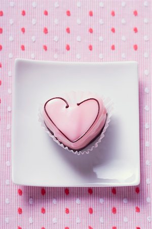 simsearch:614-06044153,k - Pink heart-shaped petit four on plate (overhead view) Foto de stock - Sin royalties Premium, Código: 659-01863873