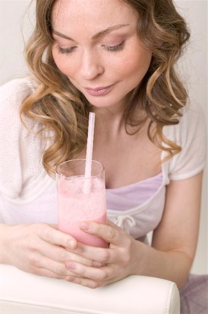 simsearch:659-03523361,k - Woman holding glass of strawberry shake with straw Stock Photo - Premium Royalty-Free, Code: 659-02214174
