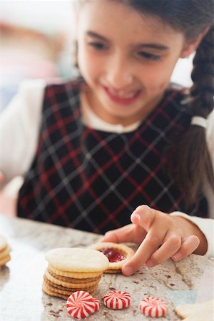 Girl taking jam biscuit from table Stock Photo - Premium Royalty-Free, Code: 659-02214214