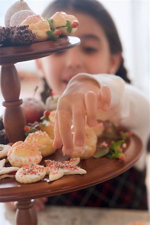 simsearch:659-03525275,k - Girl reaching for Christmas biscuit on tiered stand Fotografie stock - Premium Royalty-Free, Codice: 659-02214219