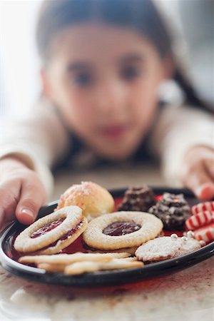 photos of christmas baking on plates - Girl reaching for plate of biscuits Stock Photo - Premium Royalty-Free, Code: 659-02214221
