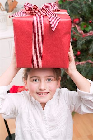Girl balancing Christmas gift on her head Stock Photo - Premium Royalty-Free, Code: 659-02214331