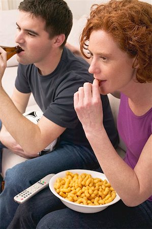 Young couple with football, beer and snack food watching TV Stock Photo - Premium Royalty-Free, Code: 659-02210824