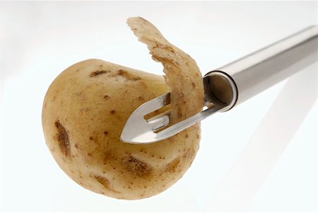 Potato with potato peeler Stock Photo - Premium Royalty-Free, Code: 659-02210867