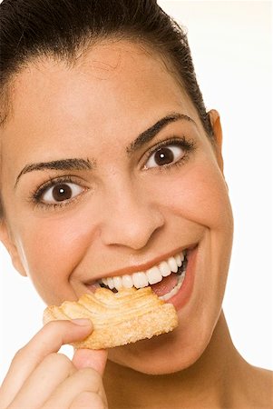 simsearch:659-02211464,k - Jeune femme mangeant une pâte sucrée Photographie de stock - Premium Libres de Droits, Code: 659-02210870
