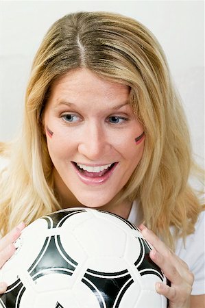 Young woman with German colours on her face holding football Fotografie stock - Premium Royalty-Free, Codice: 659-02211483