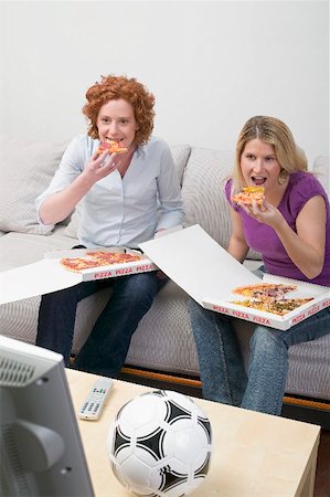 simsearch:659-03531230,k - Two friends eating pizza while watching TV Foto de stock - Sin royalties Premium, Código: 659-02211500