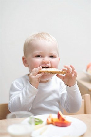 simsearch:659-02211511,k - Small boy at breakfast with half a bread roll Fotografie stock - Premium Royalty-Free, Codice: 659-02211510