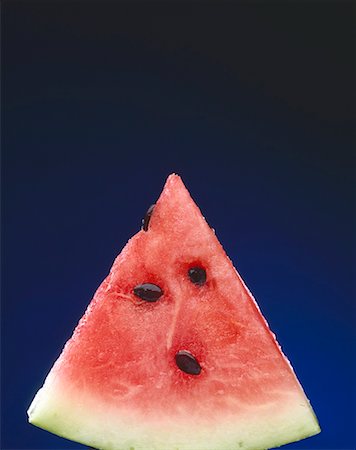 Slice of Watermelon with Seeds on a Blue Background Stock Photo - Premium Royalty-Free, Code: 659-02211547